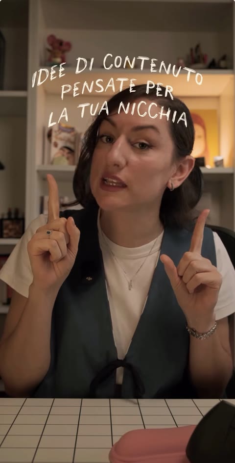 Giulia nel nuovo set, davanti a una libreria, con il testo «Idee di contenuto pensate per la tua nicchia»