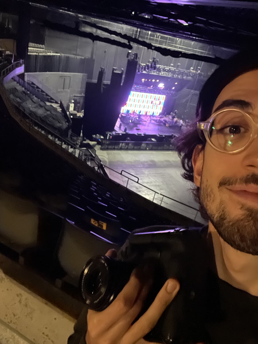 Selfie di Nic con la macchina fotografica in mano, in un'arena